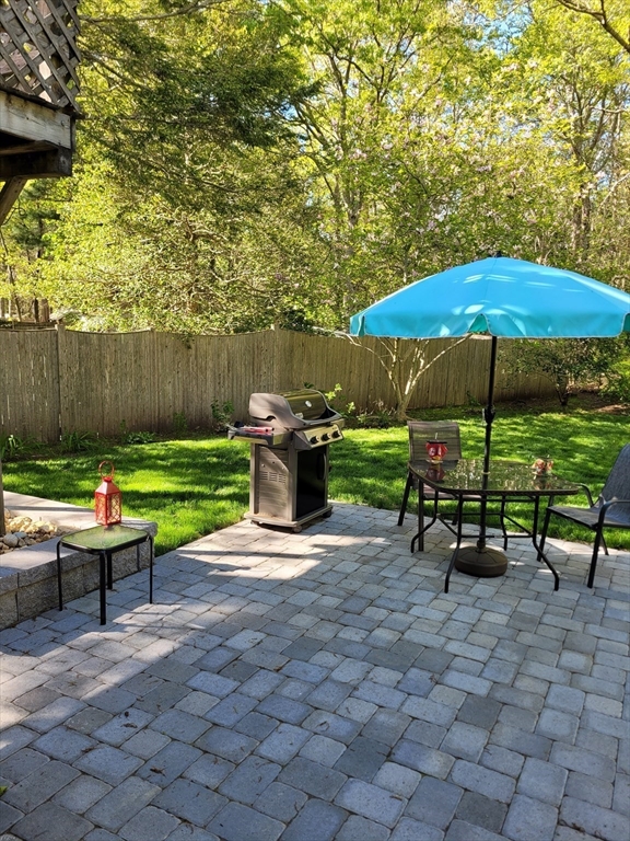 92 Santuit Pond Road Mashpee, MA 02649 - Photo 4 of 23 an outdoor space with furniture and umbrella