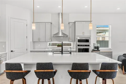 a large white kitchen with stainless steel appliances and cabinets
