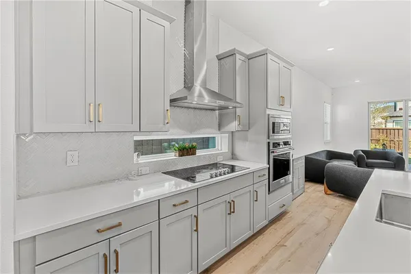 a kitchen with stainless steel appliances kitchen island granite countertop a table chairs in it and wooden floors