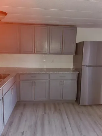 a kitchen with a refrigerator sink and cabinets