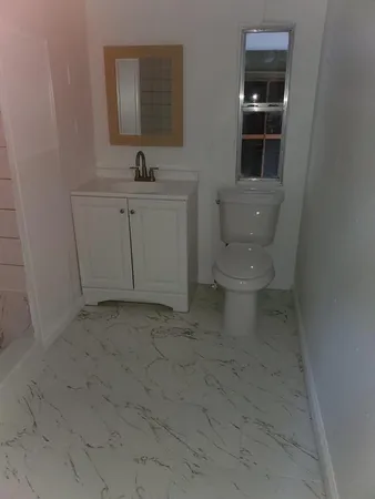 a bathroom with a toilet sink and mirror