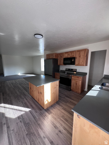 1696 South Longview Road Santaquin, UT 84655 - Photo 2 of 16 Kitchen with stainless steel range with electric cooktop, dark wood-type flooring, black microwave, freestanding refrigerator, and dark countertops