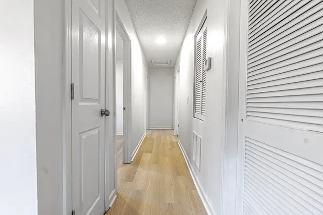 a view of a hallway with wooden floor