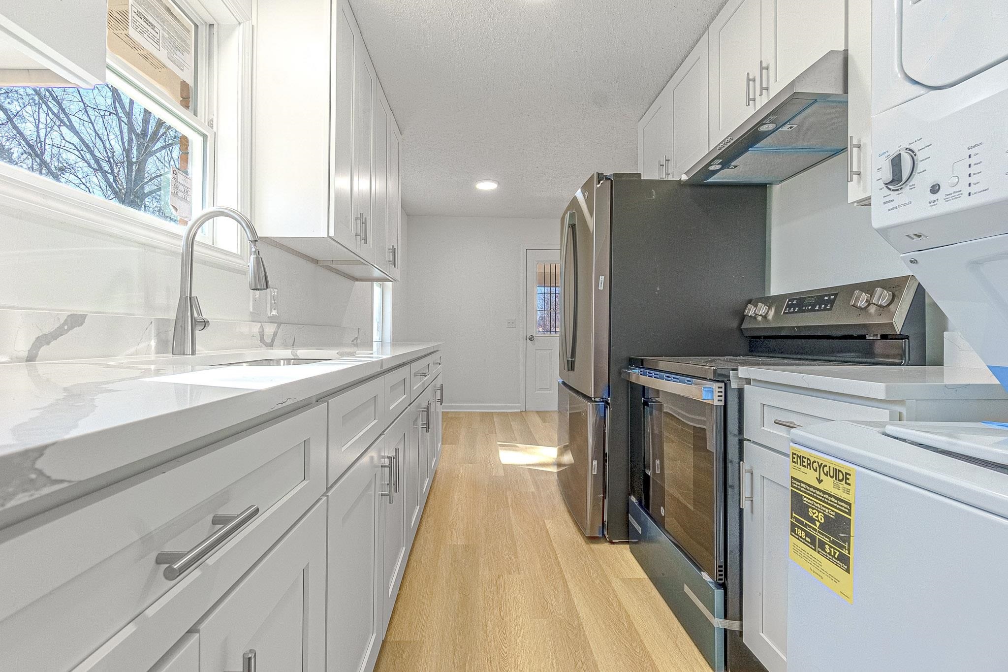 1165 Clift Road Bolivar, TN 38008 - Photo 23 of 26 Kitchen with stainless steel appliances, light wood-type flooring, healthy amount of natural light, white cabinetry, and recessed lighting