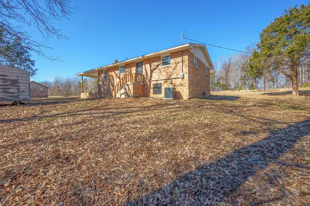 a view of a house with backyard and trees