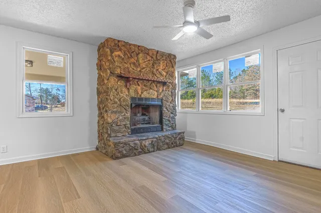 a living room with wooden floor and a fireplace