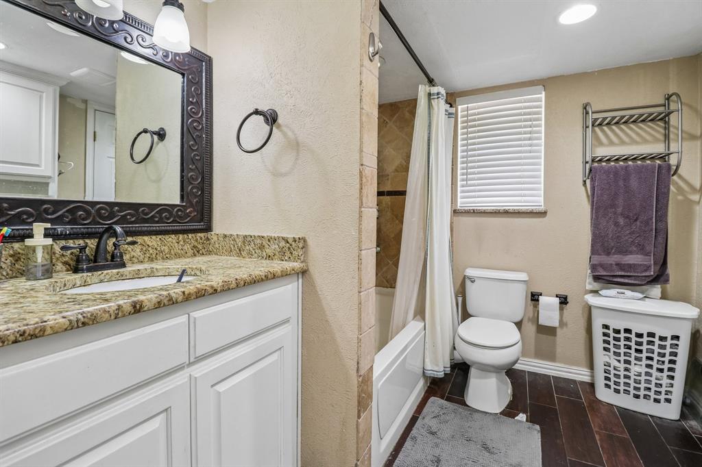 820 North Bowen Road Arlington, TX 76012 - Photo 28 of 40 a bathroom with a granite countertop toilet sink and mirror