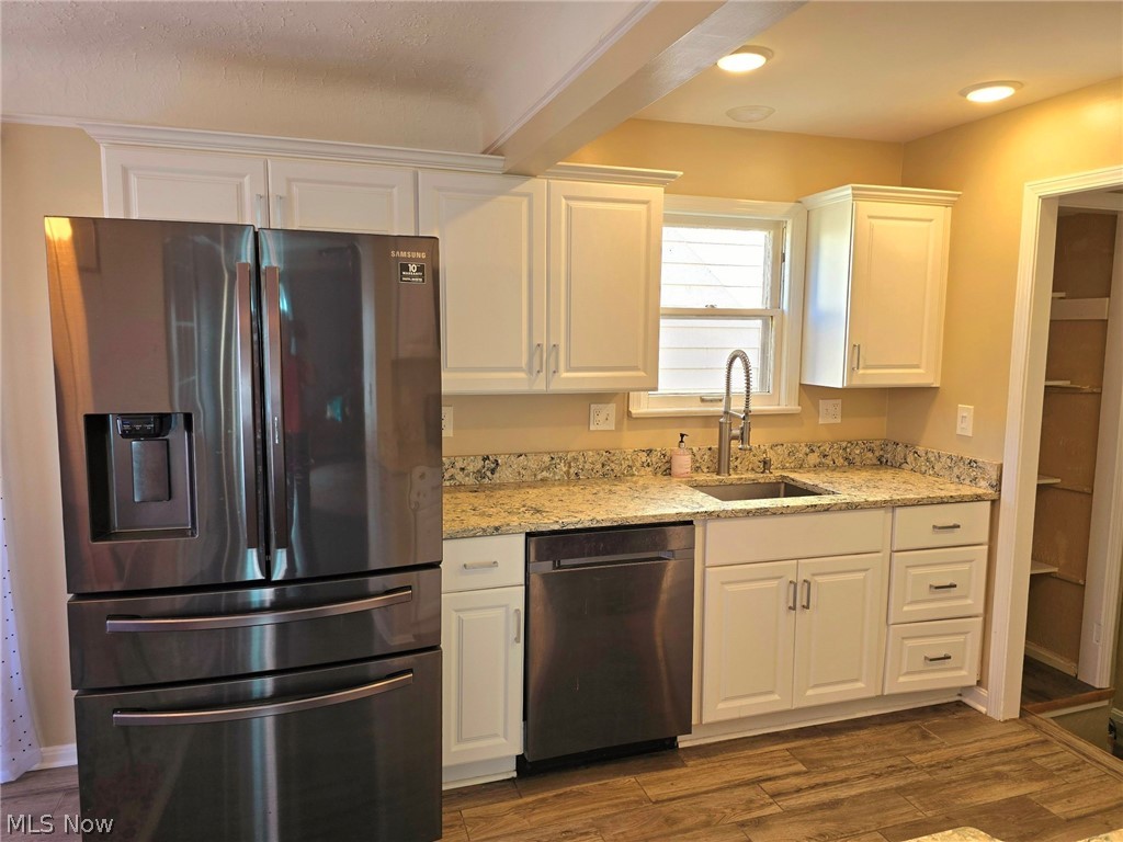 4111 Redfern Road Parma, OH 44134 - Photo 2 of 40 Kitchen with white cabinetry, open pantry, porcelain flooring, stainless steel refrigerator and dishwasher