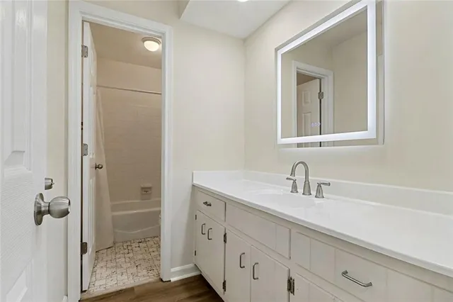 a bathroom with a shower sink and mirror
