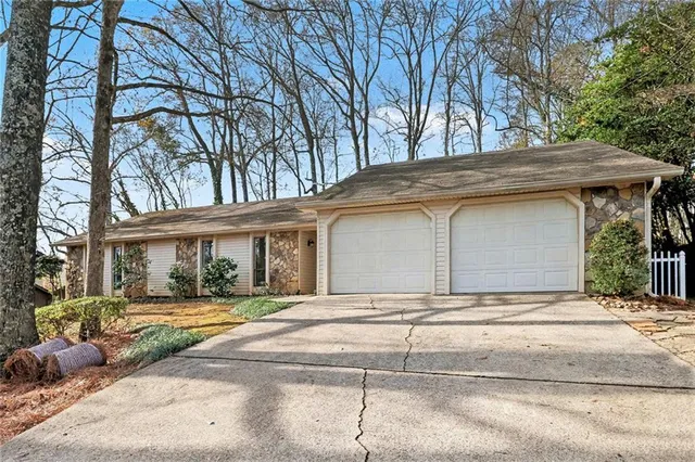 a front view of a house with a yard and potted plants