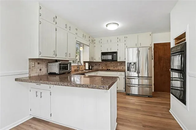 a kitchen with stainless steel appliances granite countertop a refrigerator stove microwave and sink