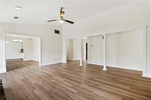 a view of an empty room with wooden floor