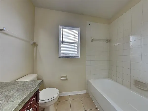 a bathroom with a granite countertop toilet a sink and bathtub