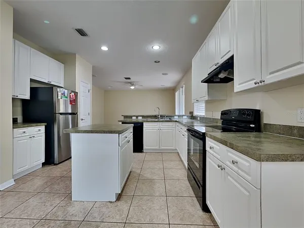 a kitchen with a sink a counter top space stainless steel appliances and cabinets