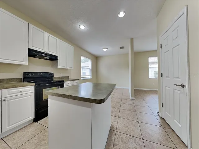 a kitchen with granite countertop a sink and cabinets
