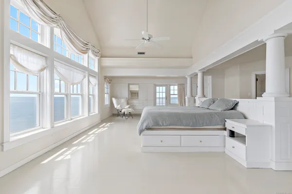 a spacious bedroom with a large bed and a chandelier