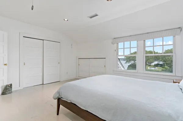 a spacious bedroom with a bed and a window