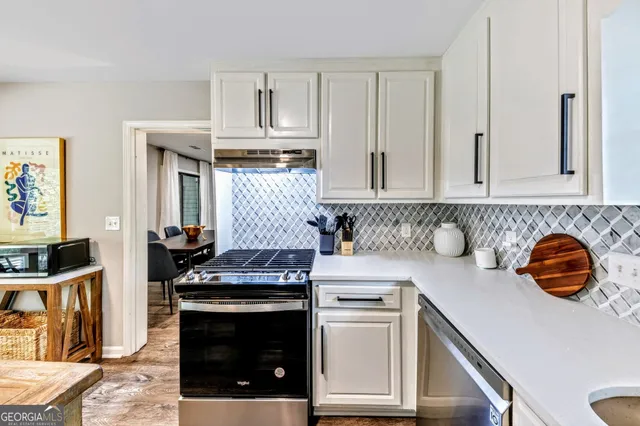 a kitchen with stainless steel appliances a stove a sink and a microwave