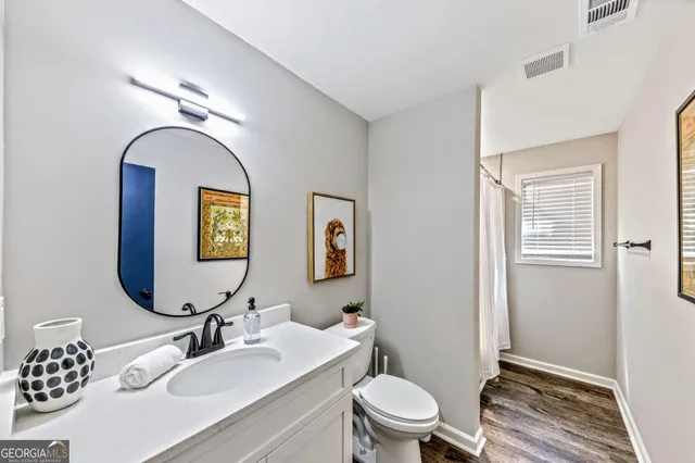 a bathroom with a toilet a sink and mirror