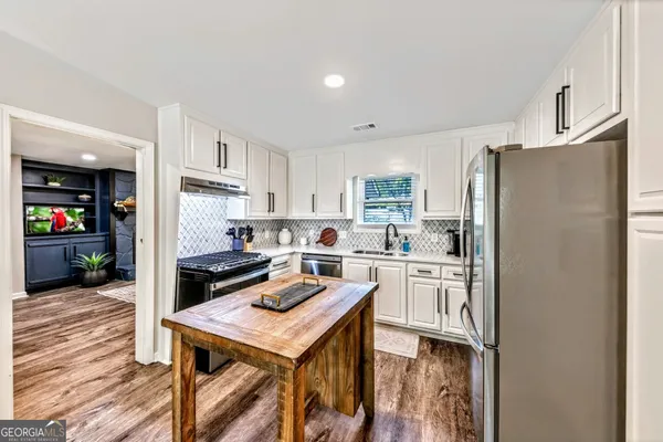 a kitchen with refrigerator cabinets and wooden floor