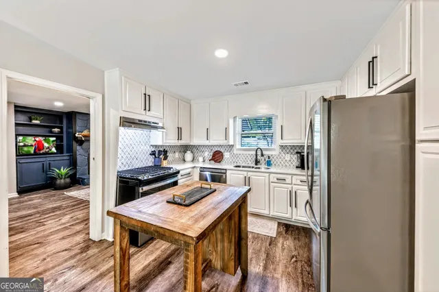 a kitchen with refrigerator cabinets and wooden floor
