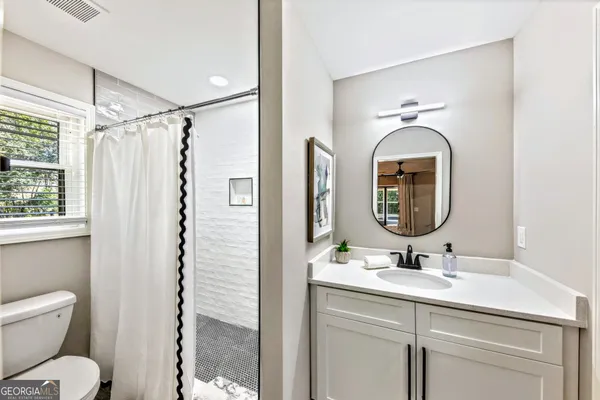 a bathroom with a toilet sink and mirror