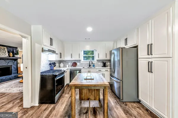 a kitchen with stainless steel appliances a stove a refrigerator and a refrigerator