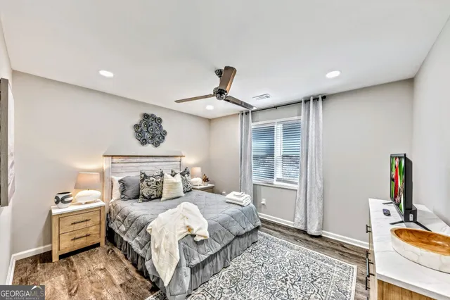 a bedroom with a bed and wooden floor