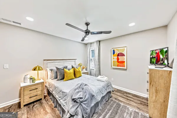a bedroom with bed and wooden floor