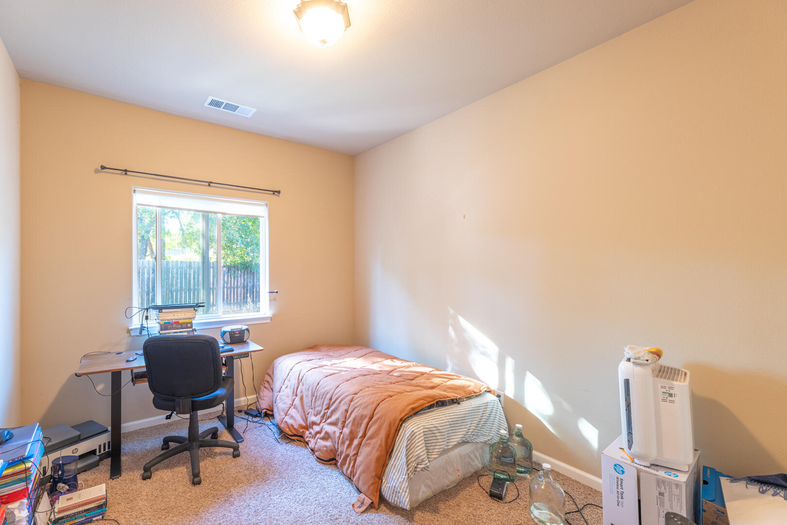 5442 Cedars Road Redding, CA 96001 - Photo 8 of 11 a bedroom with a bed a desk and chair with wooden floor