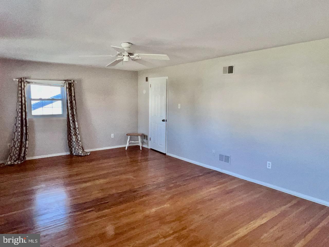 918 Rockwell Road Wilmington, DE 19810 - Photo 36 of 80 an empty room with wooden floor chandelier fan and windows