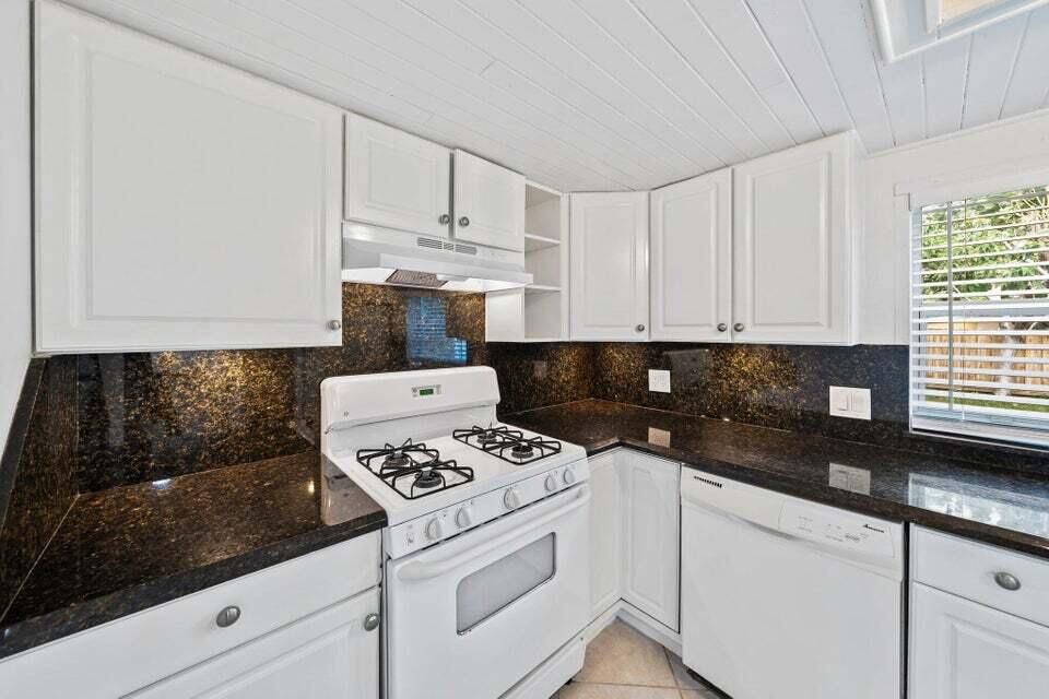 5889 Williamson Road Jupiter, FL 33458 - Photo 15 of 27 a kitchen with white cabinets and appliances