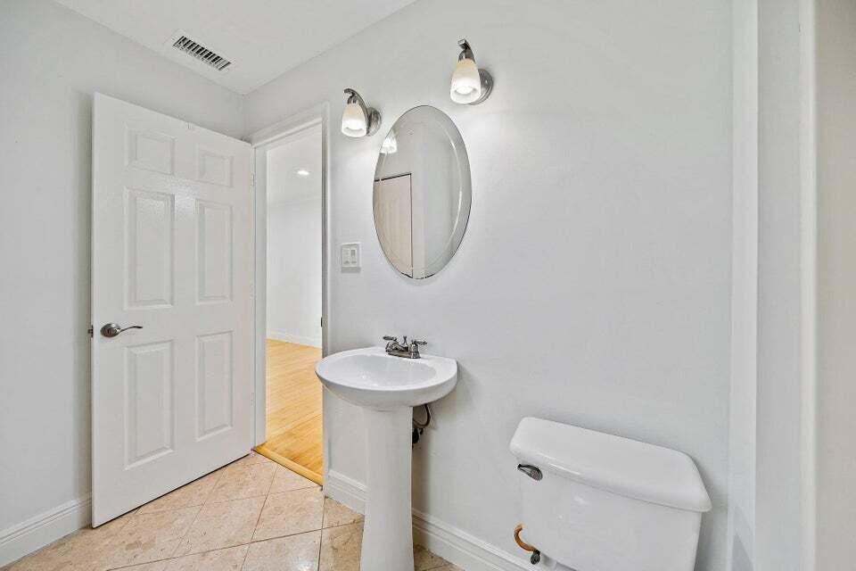 5889 Williamson Road Jupiter, FL 33458 - Photo 21 of 27 a bathroom with a toilet sink and mirror