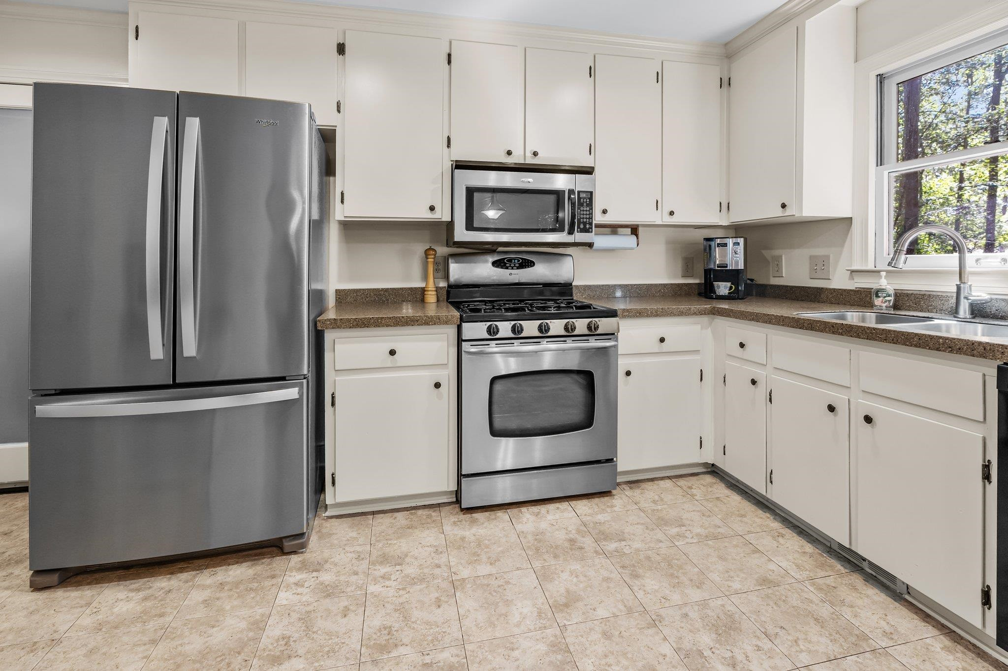 4918 Highgate Drive Durham, NC 27713 - Photo 6 of 44 a kitchen with stainless steel appliances granite countertop a stove a refrigerator and a white cabinets