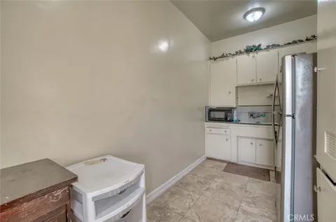 a kitchen with white cabinets and white appliances