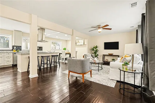 a living room with furniture kitchen view and a flat screen tv