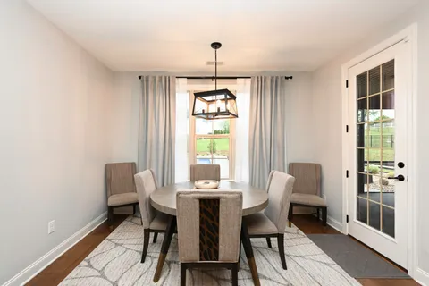 a dining room with furniture a chandelier and wooden floor
