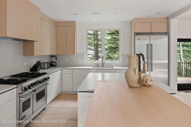 a kitchen with granite countertop a stove a sink and a refrigerator
