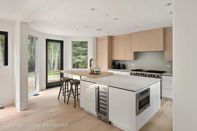 a kitchen with a white stove top oven cabinets table and chairs
