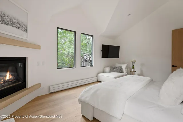 a spacious bedroom with a bed and a flat screen tv