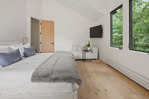 a bedroom with a bed and a flat screen tv