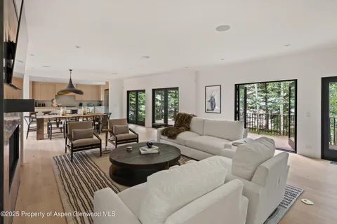 a living room with furniture kitchen view and a large window