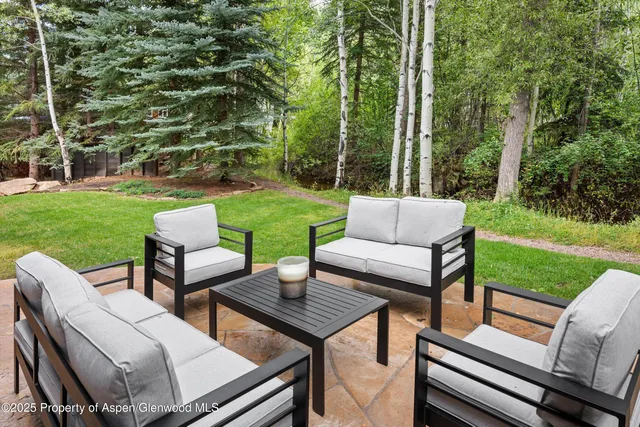 a view of a patio with couches dining table and chairs with wooden fence