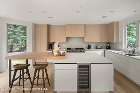 a kitchen with a stove a window cabinets and a table