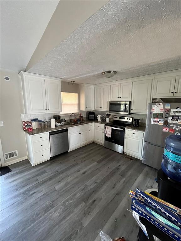 1915 Matthew Way Lithonia, GA 30058 - Photo 5 of 10 a kitchen with wooden floors and white stainless steel appliances