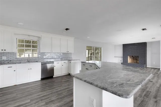 a kitchen with granite countertop a sink and a stove top oven