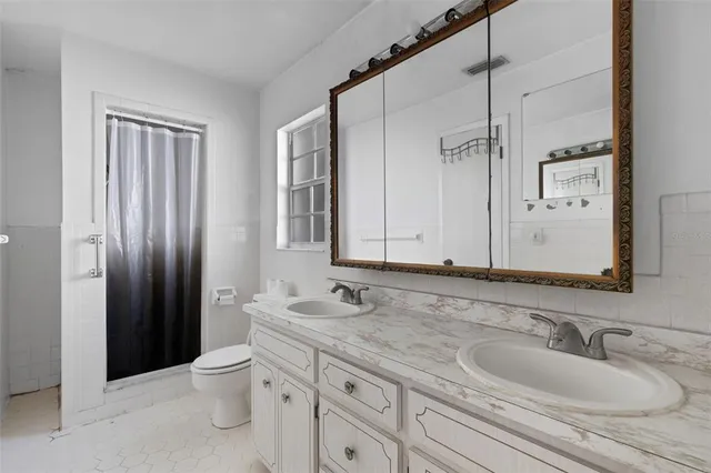 a bathroom with a granite countertop sink toilet and shower