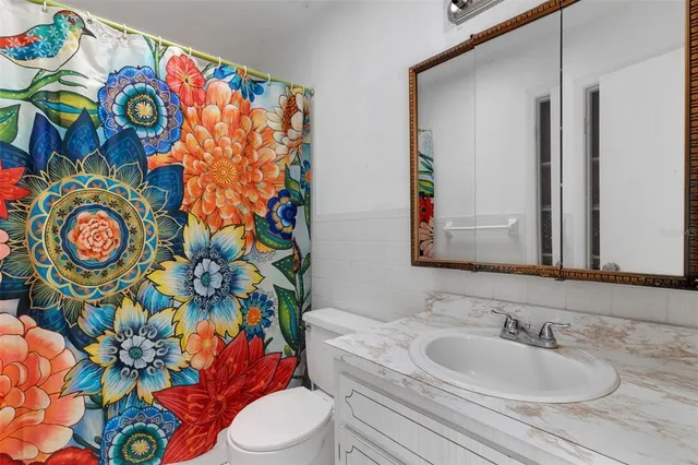 a bathroom with a sink mirror vanity and toilet