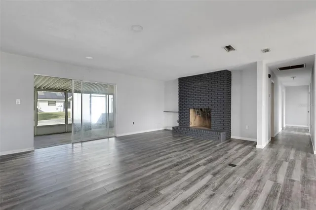 a view of empty room with wooden floor and fireplace