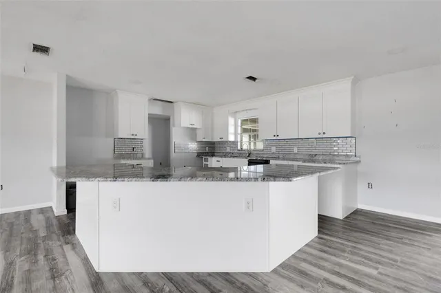a kitchen with stainless steel appliances granite countertop a sink and cabinets